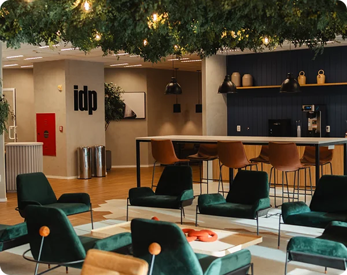 Lounge com poltronas verdes e o letreiro idp